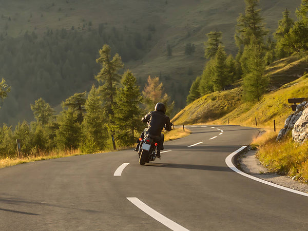 Man on cruiser riding along mountainside road